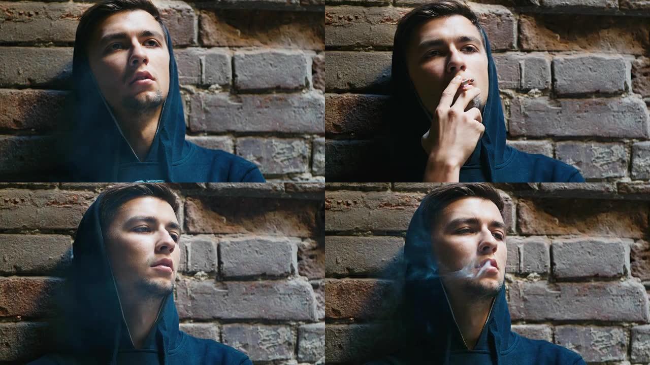 年轻人在废弃的房子里抽烟。概念: 绝望、失业、抑郁