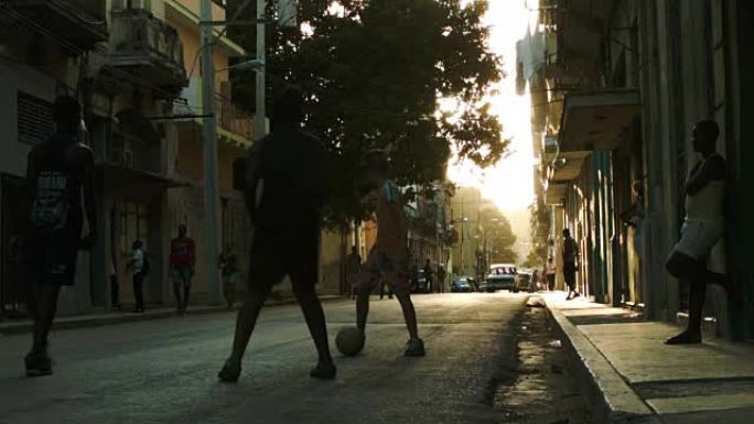 在哈瓦那老城的人行道上踢足球的孩子