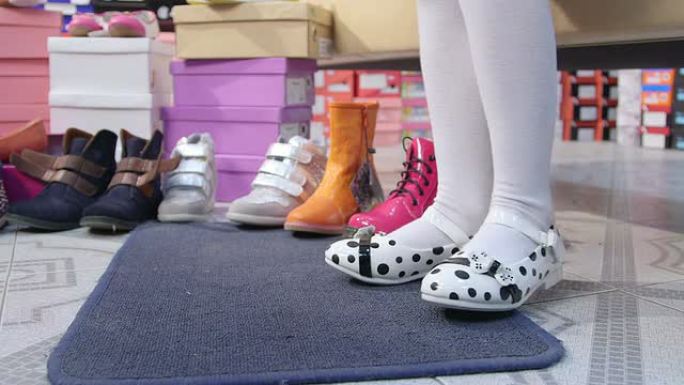 小女孩在儿童鞋店选择和试穿新平底鞋