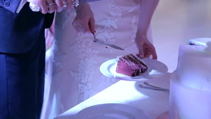 新婚夫妇把蛋糕放在盘子里。