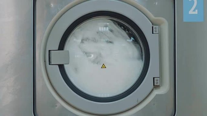 公共洗衣房的一台大型洗衣机，带旋转滚筒
