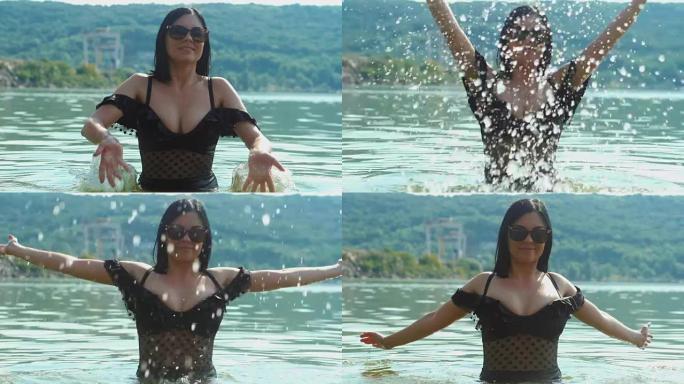 慢动作: 穿着黑色复古泳衣和太阳镜的女人在河里玩水。十几岁的女孩在夏天的海滩上游泳和飞溅。享受大自然