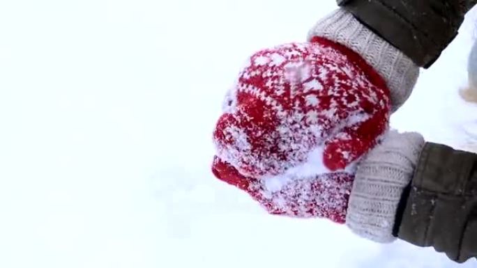 穿着针织连指手套做雪球的女性手