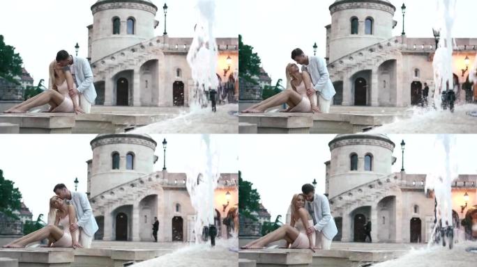 年轻的性感夫妇在巴黎的白色大理石喷泉上轻吻