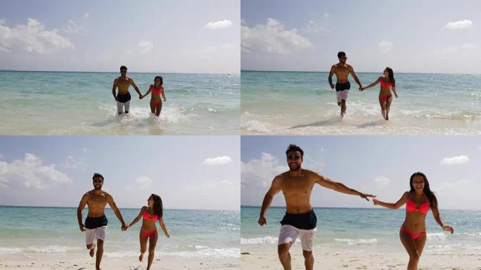 暑假里，海滩上的人们牵着手从水里奔跑，快乐的男人和女人恋爱了