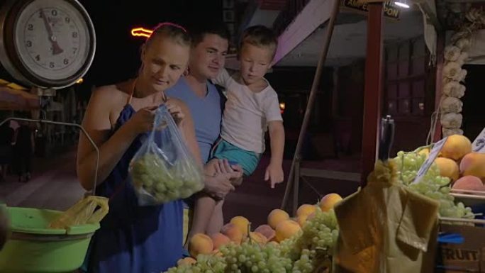 家庭在街头市场上购买水果