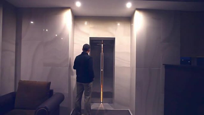 男人晚上可以坐下来，打开酒店大楼的电梯