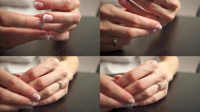年轻女子用漂亮的指甲油在手指上戴钻石戒指