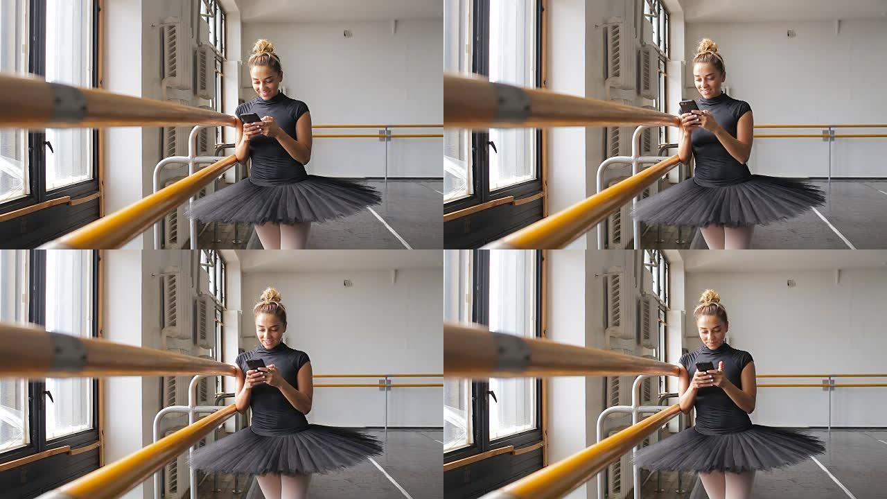 芭蕾舞演员在大型训练馆中使用智能手机