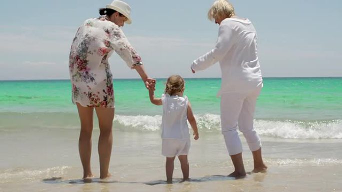 奶奶妈妈和小女孩在海滩玩耍
