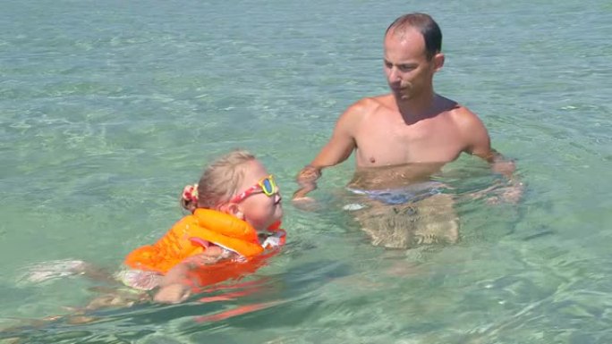 父亲带小女儿穿充气救生衣学游泳