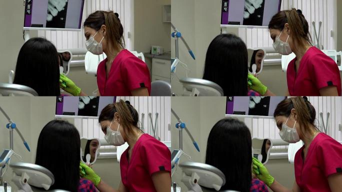 牙医在解释治疗时，病人正在照镜子。年轻的女牙医正在检查病人。4k拍摄
