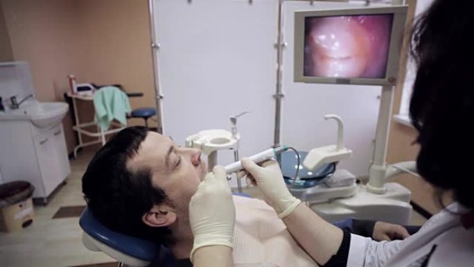 牙医用口内照相机检查病人的口腔。