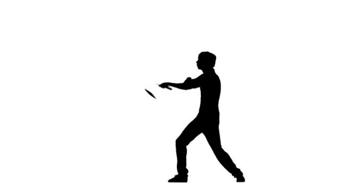 年轻的空手道或跆拳道男子熟练地旋转双节棍，剪影