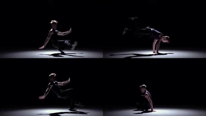 现代金发霹雳舞男子跳跃开始在黑色、阴影、慢动作上跳舞