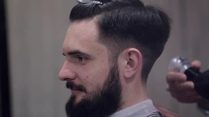 男理发师在理发店用滑石粉为留胡子的顾客理发