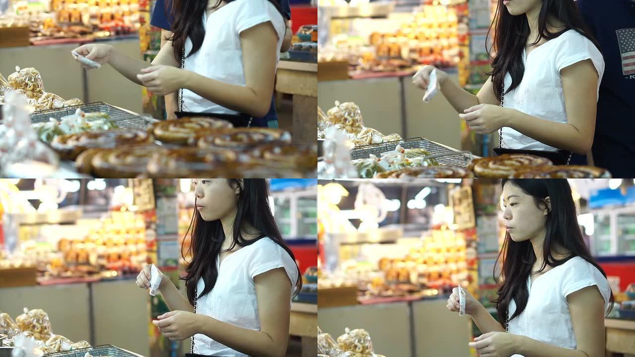 泰国清迈-2015年4月: 女孩在亚洲当地市场购物和支付现金