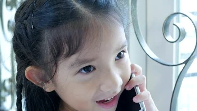 小女孩在窗户附近用电话