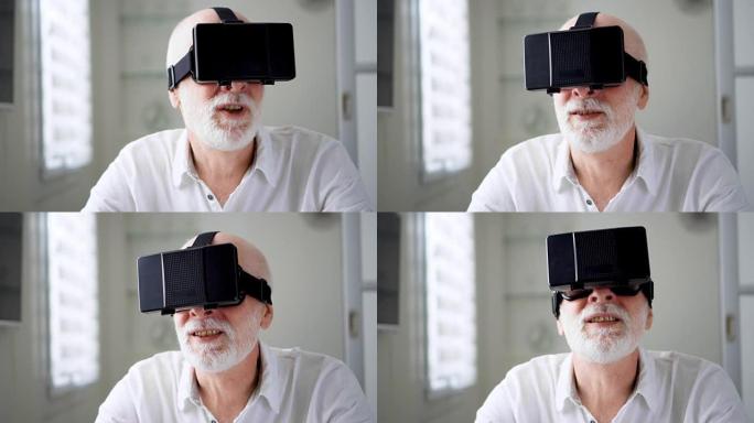 好看的帅气的高级男子在白色使用VR 360眼镜在家里。活跃的现代老年人