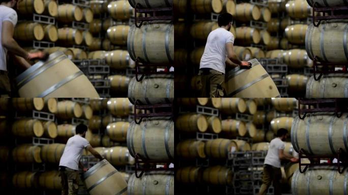 酿酒师的酒桶通过在法国波尔多葡萄园的大型储藏地窖中滚动而上下移动