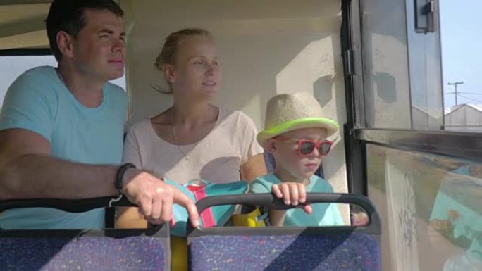 带着孩子乘公共汽车旅行并看着窗外的家庭