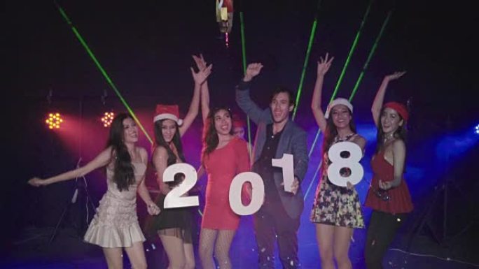 亚洲年轻团体朋友用手吹来五颜六色的五彩纸屑庆祝2018