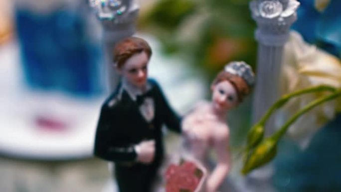 闪烁背景的婚礼蛋糕上的新娘和新郎人物