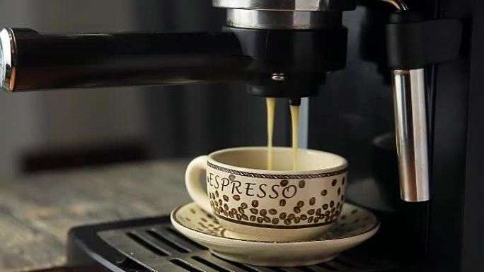 浓缩咖啡机将看起来浓郁的新鲜咖啡倒入整洁的杯子中