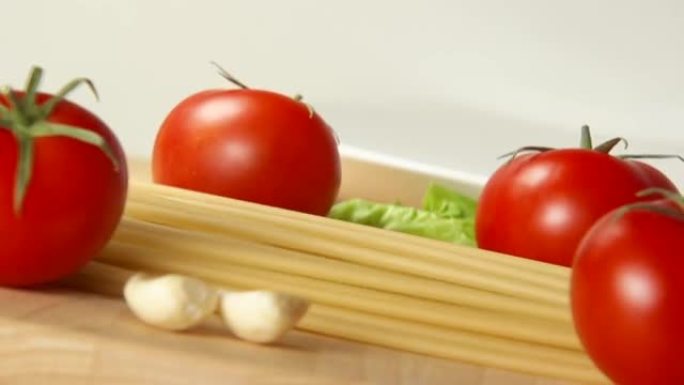 意大利面条落在成熟的西红柿之间的桌子上