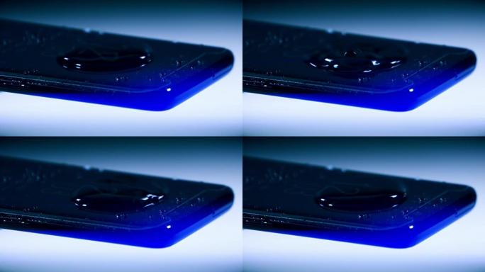 水滴落在现代黑色手机的屏幕上