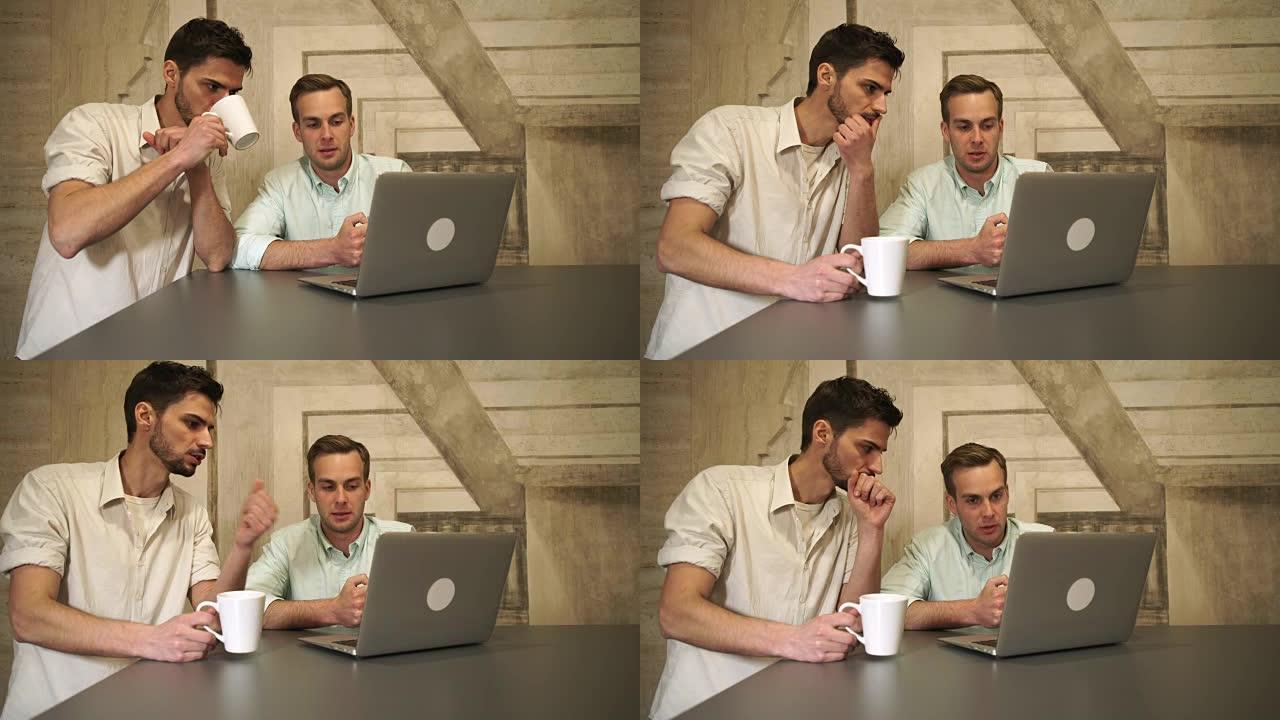 咖啡馆里的两个年轻人看着屏幕电脑聊天