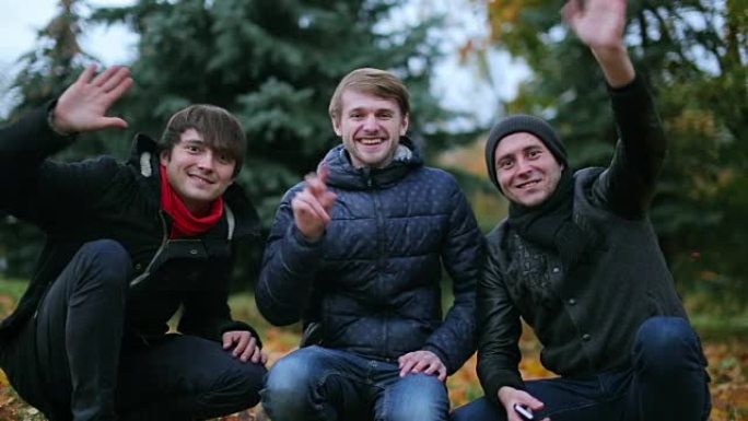 三个年轻积极的男性青少年打招呼，向镜头打招呼并开始skype通话