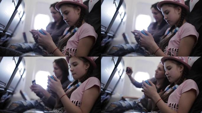 家人在飞机上度假，时间通过杂志和智能手机