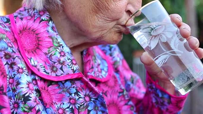 老年女性拿着药片喝水