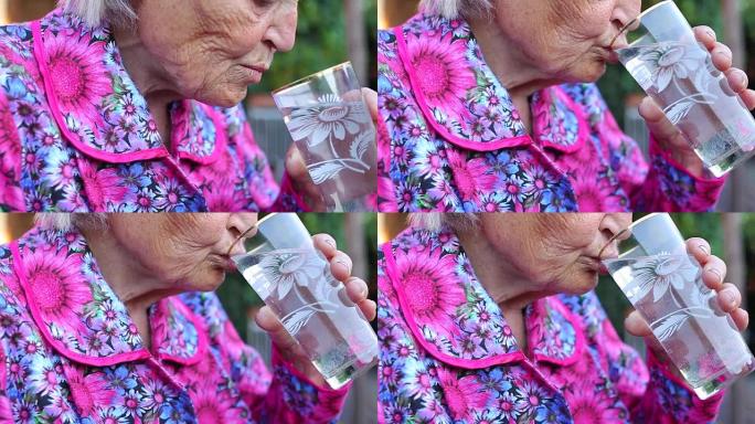 老年女性拿着药片喝水