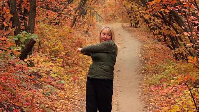 金发女孩在秋天的森林里做运动