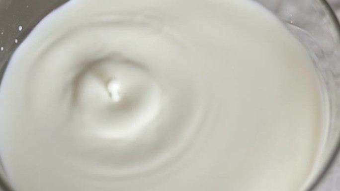 一滴牛奶在一碗牛奶中慢慢落下。