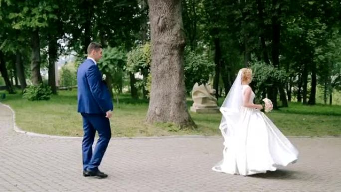 新郎在公园里跟着她快乐的新娘
