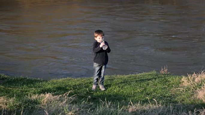 小男孩在河边喝水
