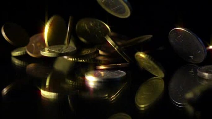 各国硬币的货币和价值落在黑色的反光表面上，慢动作。金钱、商业、收入概念。