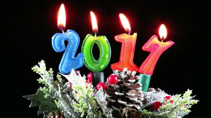 燃烧彩色数字形状的蜡烛，以庆祝即将到来的新年2017，在特定季节的冬季装饰中，冷杉锥，叶子和小树枝上