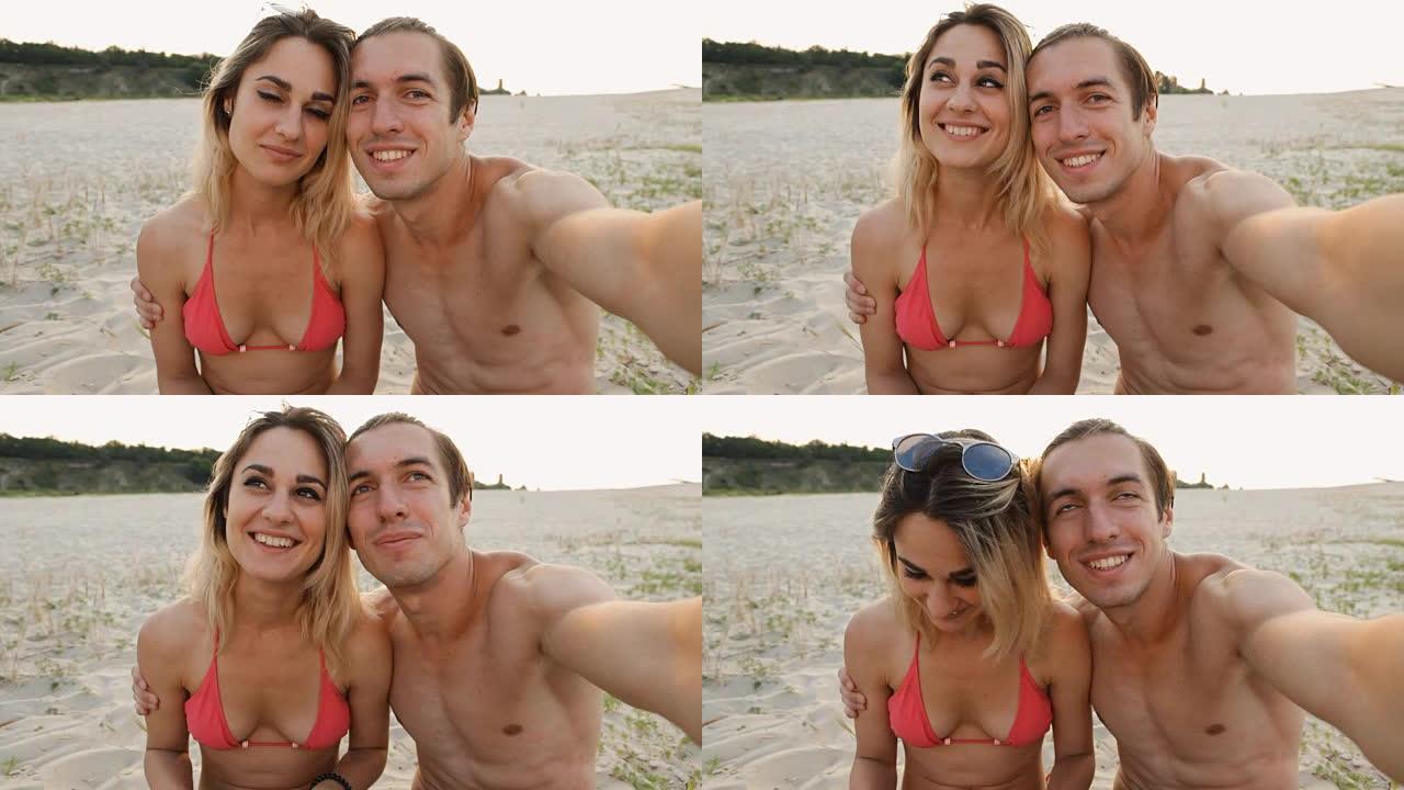 年轻的幸福夫妇在日落时在海滩上自拍