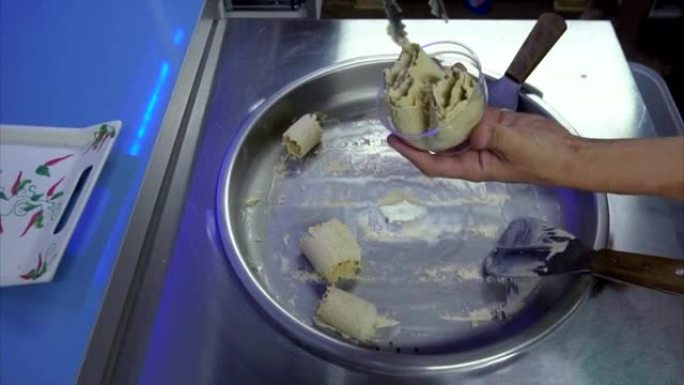 男性手将油炸冰淇淋放入塑料甜点碗中