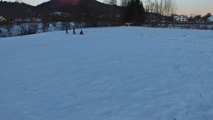 父亲拉雪橇，孩子们在冬天玩得开心，鸟瞰图