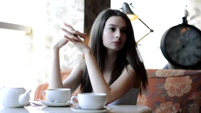 沉思，体贴的美女在咖啡馆喝咖啡