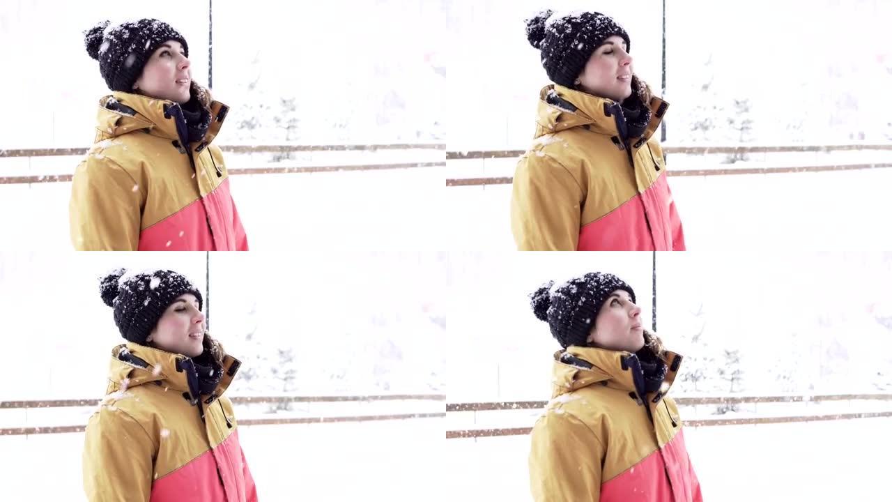 下雪时，穿着鲜艳的冬衣和帽子的年轻女子站在外面