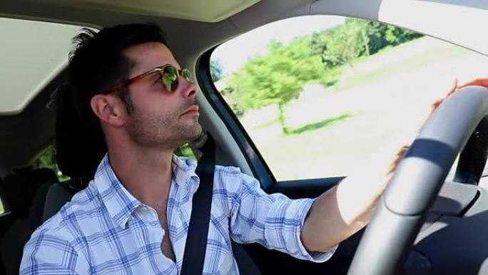 英俊的男人随便开车。在高速公路上放松的司机。假日旅行的人。戴墨镜的男子自然驾驶