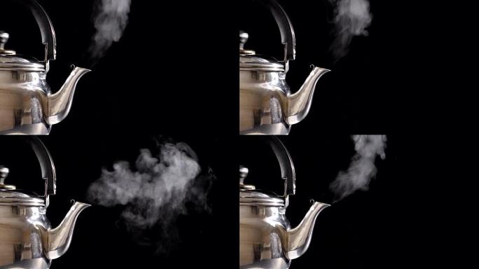 黑色背景上沸腾的茶壶中的蒸汽