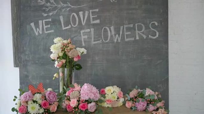 粉笔板，砖墙上有鲜花环绕的文字。在花店工作室