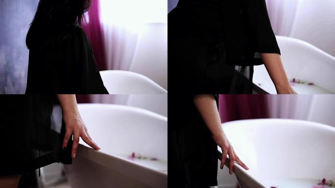 年轻迷人的女人来到浴缸前，准备洗一个装满牛奶和鲜花的热水澡。慢动作镜头